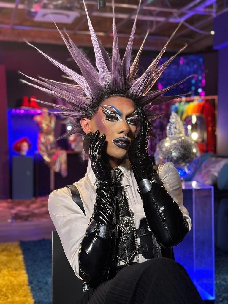 Ina Propriette in a dramatic spiked silver headdress and black gloves backstage at Sheer City